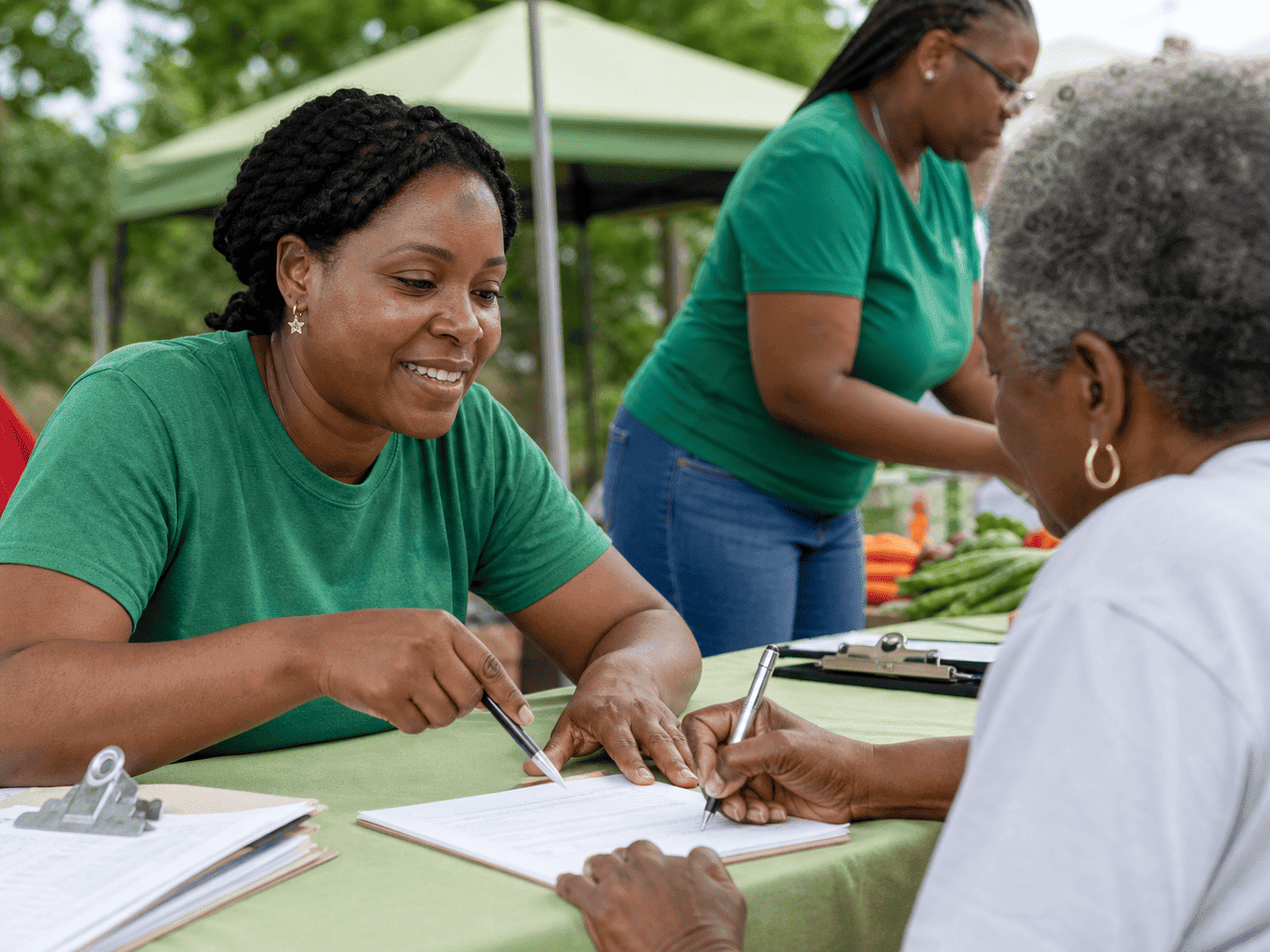 Volunteer helping a neighbor complete a registration form